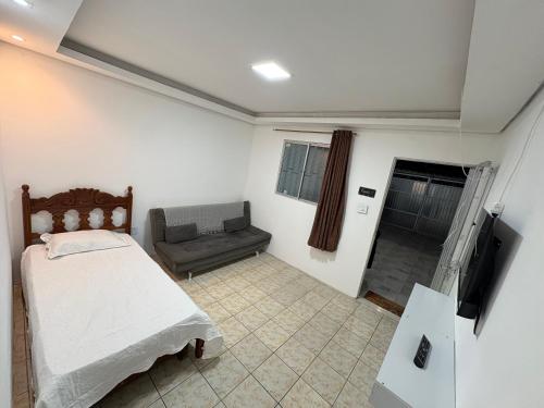 ein Schlafzimmer mit einem Bett und einer Couch in der Unterkunft Casa em Angra dos Reis, no parque mambucaba in Angra dos Reis