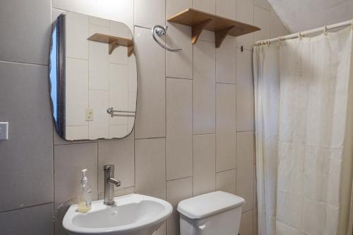 a bathroom with a sink and a toilet and a mirror at Cabañas San Miguel in Alto Boquete