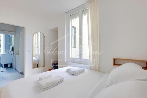 a bedroom with a white bed with two towels on it at New, Elegant & Cozy, 2 Guests in Bagneux