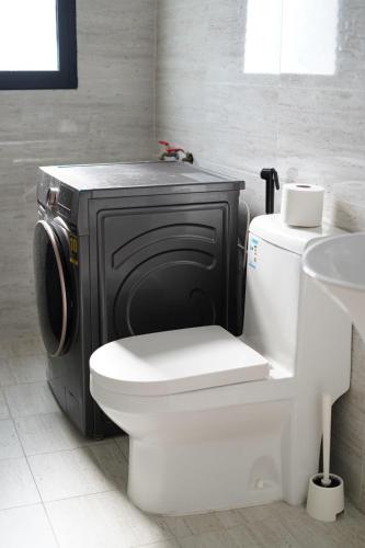 een badkamer met een toilet en een tv. bij Alsoltan stay in Dammam