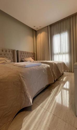 een groot bed in een slaapkamer met een raam bij Alsoltan stay in Dammam