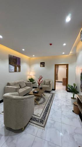 a large living room with couches and a table at شقق يودج in Tabuk