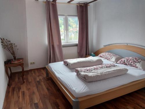 a bedroom with a bed with two pillows and a window at Waldblick in Hirschhorn in Hirschhorn
