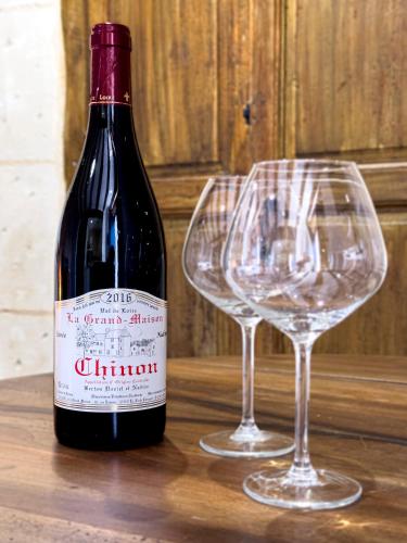 a bottle of wine and two wine glasses on a table at Le Logis de cœur in Azay-le-Rideau