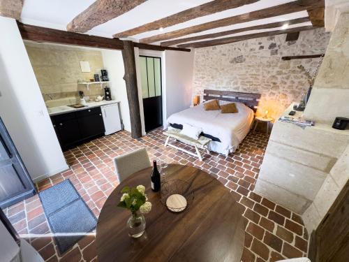 a bedroom with a bed and a table in a room at Le Logis de cœur in Azay-le-Rideau