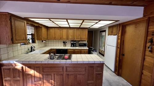 a kitchen with wooden cabinets and a white refrigerator at Little Bear Lodge in Springville