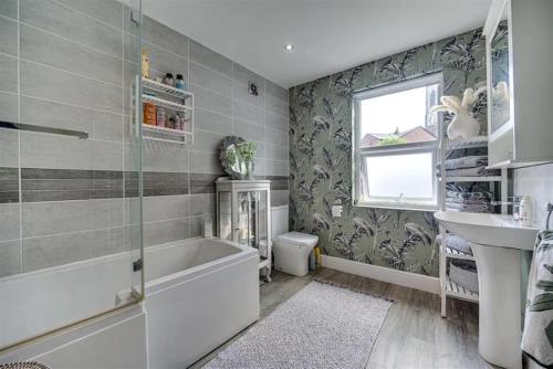 a bathroom with a tub and a sink at Moody Street in Congleton