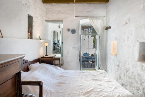 a bedroom with a bed in a white room at Traditional Hora House Serifos in Serifos Chora