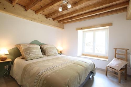 Un dormitorio con una cama grande con ventana. en Lauseig, en Lourdios-Ichère