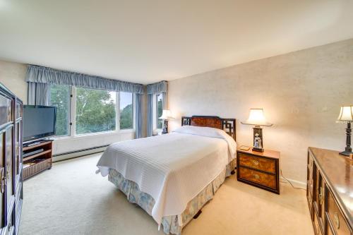 a bedroom with a large bed and a television at Charming Retreat with Deck about 4 Mi From Casco Bay! in Orrs Island