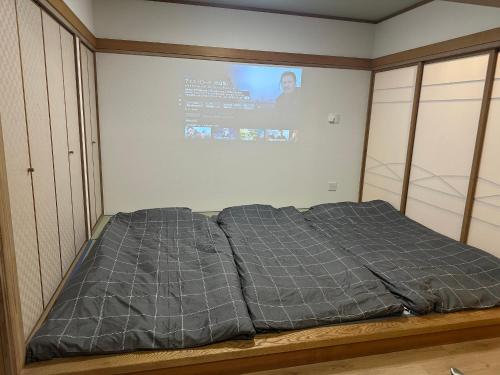 Un pat sau paturi într-o cameră la 元気堂ビル - 新幹線高崎駅徒歩6分 - 和室洋室完備 - Wifiﾌﾟﾛｼﾞｪｸﾀｰ有 - 最大10名