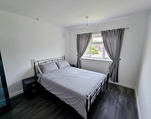 une chambre avec un lit et une fenêtre dans l'établissement Lovely 4 Bed Dudley Home, à Sedgley