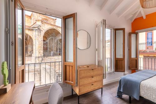 a bedroom with a bed and a large window at La casa de Santa María in Laredo