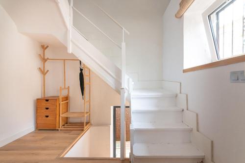 a white staircase in a home with a window at La casa de Santa María in Laredo