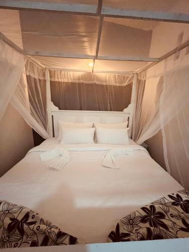 a bed in a small room with white sheets and pillows at Amurasan beach studio in Tangalle