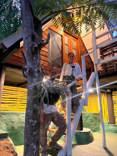 a man and a woman standing in front of a tree house at moye moye Ella in Ella