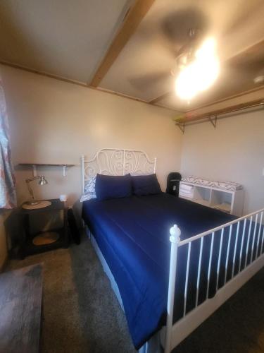 a bedroom with a bed with a blue comforter at Cottage 2 on Ranch with Fishing & Camping in McKinney