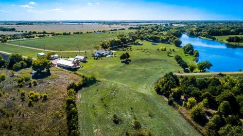 an aerial view of a house on a farm next to a river at Cottage 2 on Ranch with Fishing & Camping in McKinney