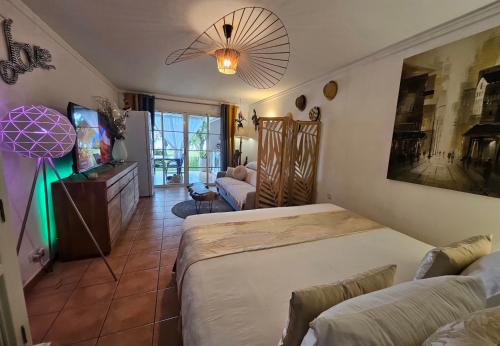 une chambre avec deux lits et un salon dans l'établissement La Perle des Caraïbes, à Sainte-Anne