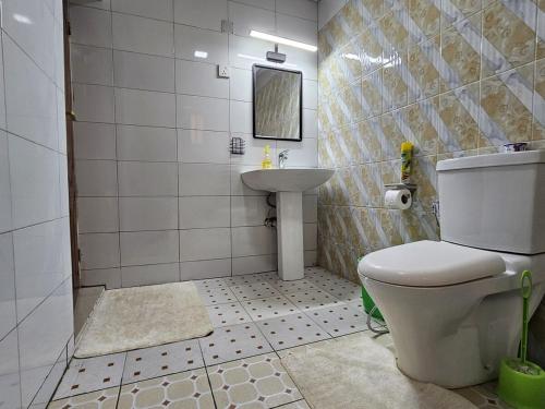 um banheiro com vaso sanitário e pia em Little Paradise em Kigali