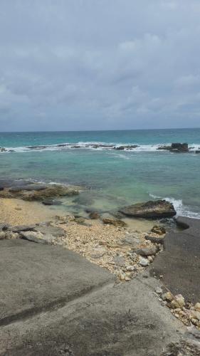 ein Strand mit dem Meer und Felsen im Wasser in der Unterkunft Villa Manakit in Petit-Bourg