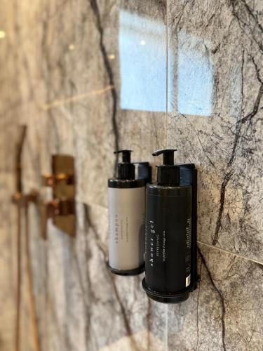 two bottles of soap on a stone wall at Elysia Room - Évasion, Balnéo et Sauna in Collioure
