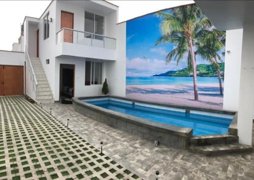 une villa avec piscine et une fresque murale représentant une plage dans l'établissement Bravos Hospedaje Punta Negra, à Punta Negra
