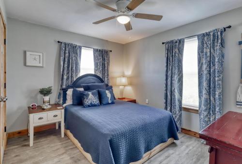 Schlafzimmer mit einem blauen Bett und einem Deckenventilator in der Unterkunft Whitesands Beach House - North in Fort Morgan