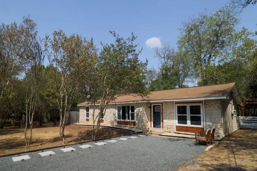 a small brick house with a porch at Manchaca 4 bedroom sleeps 10 Pool and Hot tub in Manchaca