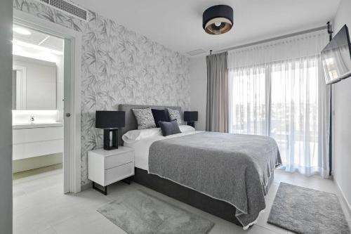 - une chambre avec un lit, une fenêtre et un lavabo dans l'établissement Modern and Luxury Apartment in Flamenca Village, à Orihuela Costa