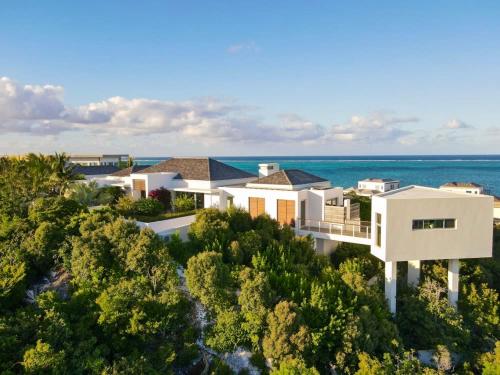 Una vista aérea de una casa con el océano al fondo. en Villa Cosmo with Oceanview, en Turtle Cove