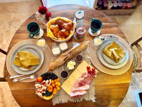 Le Coin Tranquille في لا روك-غاجياك: طاولة خشبية مليئة بأطباق الطعام والخبز