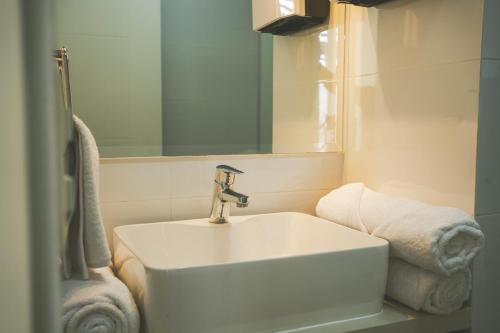 a bathroom with a sink and a mirror and towels at Duplex Moderno y Espacioso en Miraflores in Lima