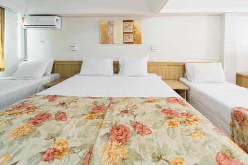 クリチバにあるHotel Golden Park Curitiba By Nacional Innのベッドルーム1室(花柄のベッドカバー付)