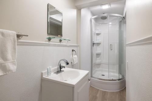 a white bathroom with a shower and a sink at Conch Key Fishing Lodge & Marina in Conch Key