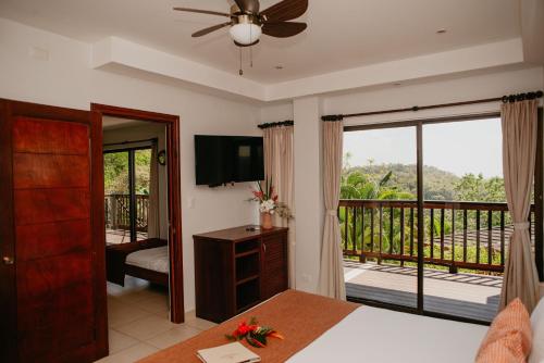 a bedroom with a bed and a balcony at Eco Boutique Hotel Vista Las Islas Reserva Natural in Paquera