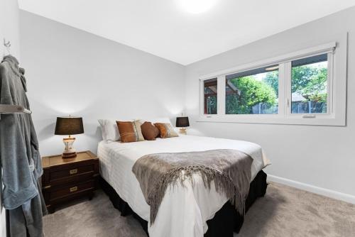 Cozy Bungalow - 5mins to The Ottawa Hospital في أوتاوا: غرفة نوم بيضاء مع سرير ونافذة