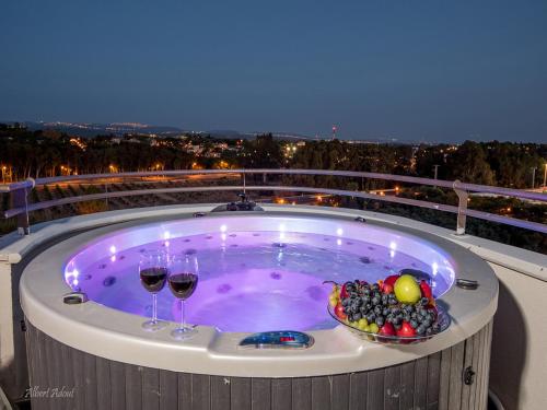 a hot tub with two glasses of wine and fruit at Siesta in Achziv in Nahariyya