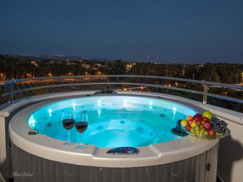 two glasses of wine in a hot tub on a balcony at Siesta in Achziv in Nahariyya