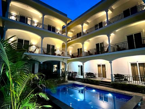 an exterior view of a building with a swimming pool at Morjim Sunset Hotel in Morjim