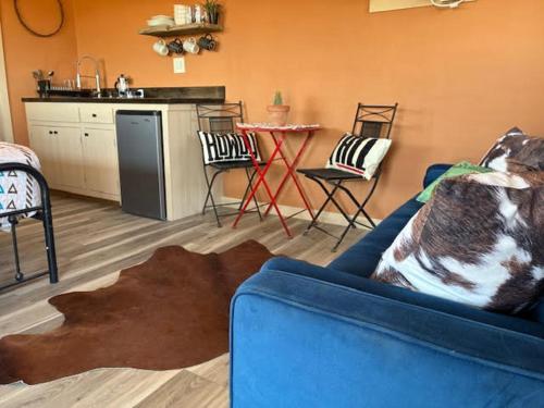 a living room with a blue couch and a kitchen at Cabin at the Hill, Close to Big Bend National Park and Terlingua Ghost Town in Terlingua