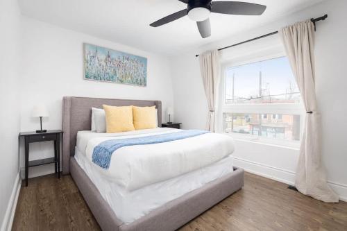een slaapkamer met een bed, een plafondventilator en een raam bij Charming 3 Beds Ossington Home in Toronto
