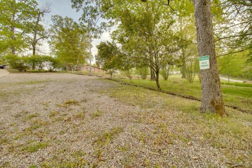 a tree in a field with a sign on it at Waterfront Home Near Mark Twain National Forest in Poplar Bluff
