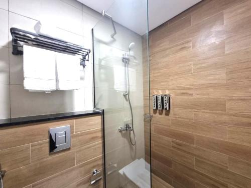 アブダビにあるElegant Pool-View 1BR Near Cleveland Clinicのガラスドア付きのシャワー付きのバスルーム