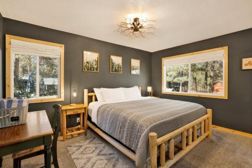 a bedroom with a bed and two windows at Country Club Cabin #357 in Big Bear City