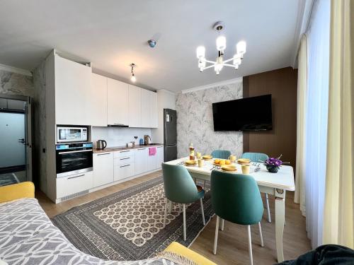 a kitchen and dining room with a table and chairs at Современный 3х комнатный апартаменты на Туране возле Барыс Арена in Astana