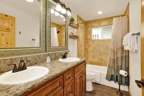 a bathroom with two sinks and a toilet and a shower at Country Club Cabin #357 in Big Bear City