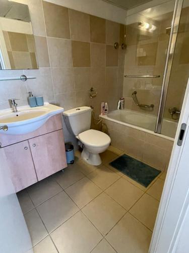 a bathroom with a toilet and a tub and a sink at Apartment in heart of Jerusalem in Jerusalem