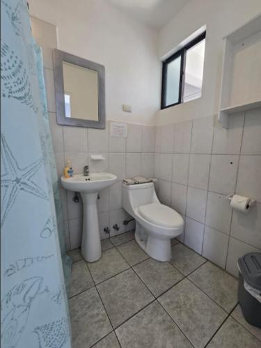 a bathroom with a toilet and a sink at Hotel Andalucía in Arica