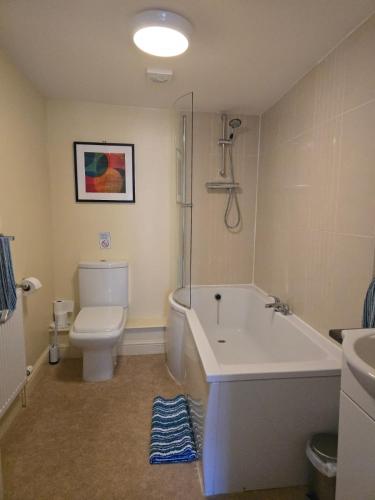 a bathroom with a tub and a toilet and a sink at Family Room - The Unicorn Hotel in Llanidloes